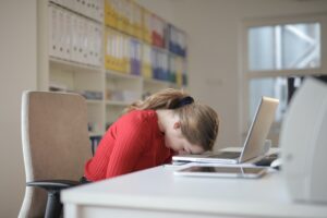 Woman sleeping on her computer in an article on alternative treatments for sleep disorders.